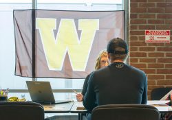 A representative from Western Michigan University assists a student during a WMU On-Site Admission Day event at KCC.