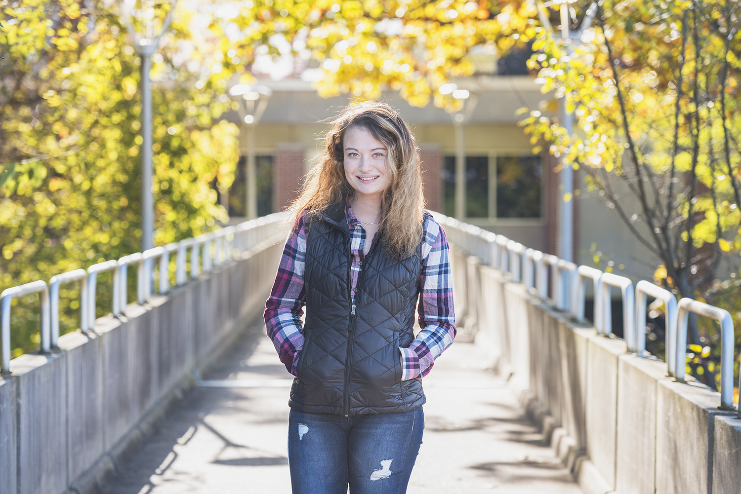 KCC student Jana Gardner poses on the bridge outside the Davidson Center on campus in Battle Creek.
