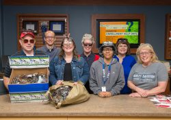 Bruin Bookstore staff pose with eyeglasses collected during a donation drive at KCC.
