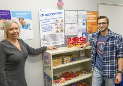 KCC Nursing professor Elizabeth Fluty, left, stands with Nursing student Isaac Lake by the Nurses in Need Open Door Pantry on campus in Battle Creek. The pantry is supplied by the KCC community to provide food, hygiene and other items to KCC Nursing students in need.