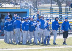 Members of KCC's baseball team congratulate players returning from the field between innings during a home game at Bailey Park in Battle Creek.