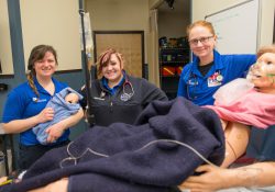 Paramedic students pose for a photo following a birthing simulation on campus.