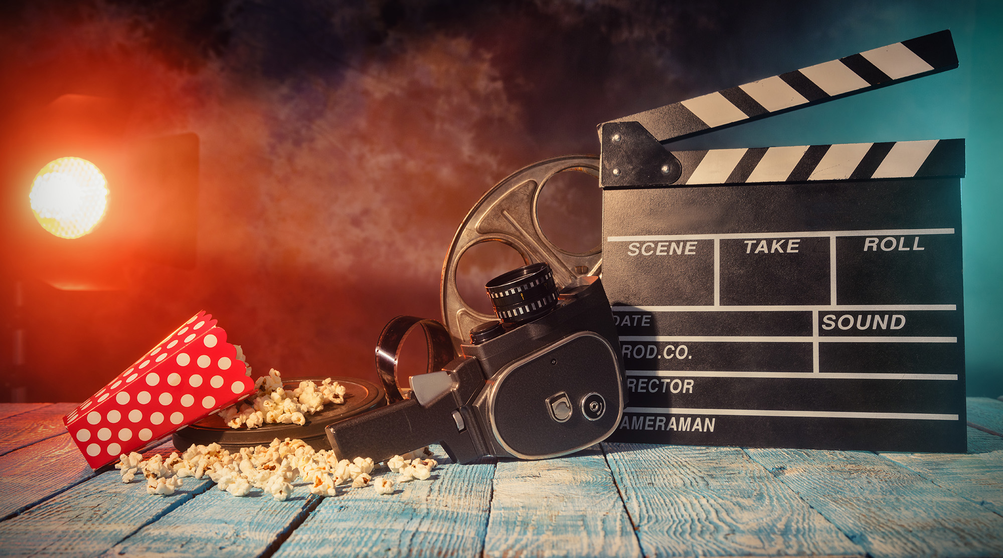 A stock photo showing retro film production accessories placed on wooden planks to communicate the concept of filmmaking.