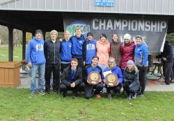 KCC's men's and women's cross-country teams pose with trophies won for winning their respective regional championships.