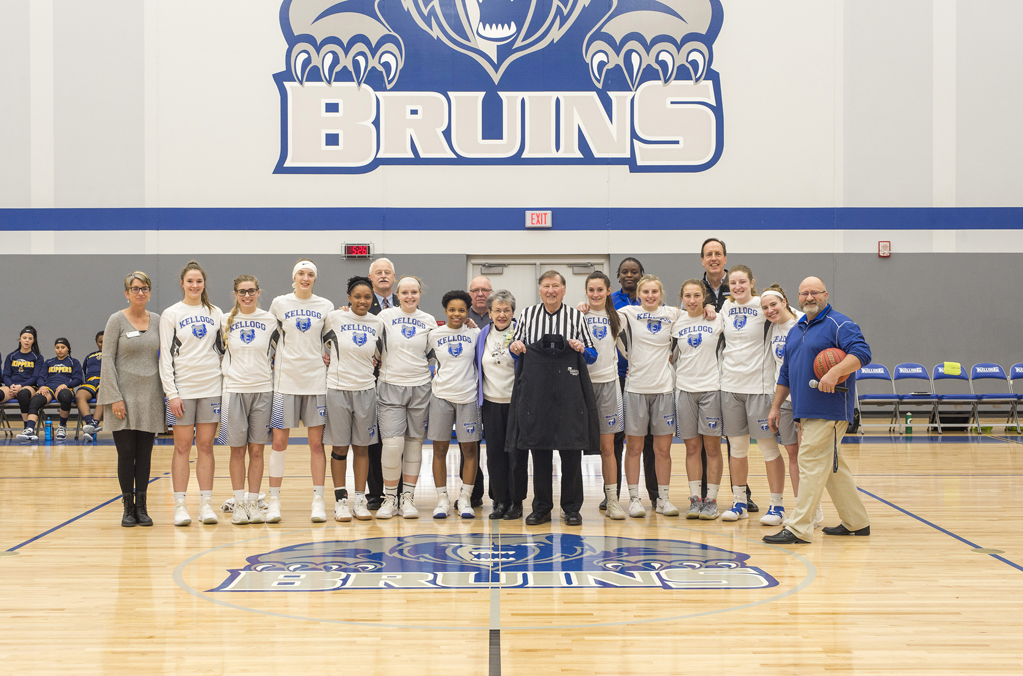 Former Battle Creek mayor Al Bobrofsky, who officiated the College's first basketball game in 1966, poses with wife Ann, the KCC women's basketball team and college officials before the start of the women's basketball game on Dec. 5, 2018.