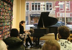 KCC alumna Abigail Mullis playing the piano for a live audience.