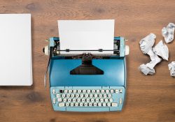 Blank paper, a typewriter and ball-up paper.