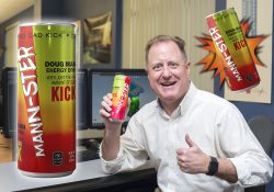 CAD professor Doug Mann gives a thumbs up while holding a can of MANN-STER energy drink in the CAD Lab.