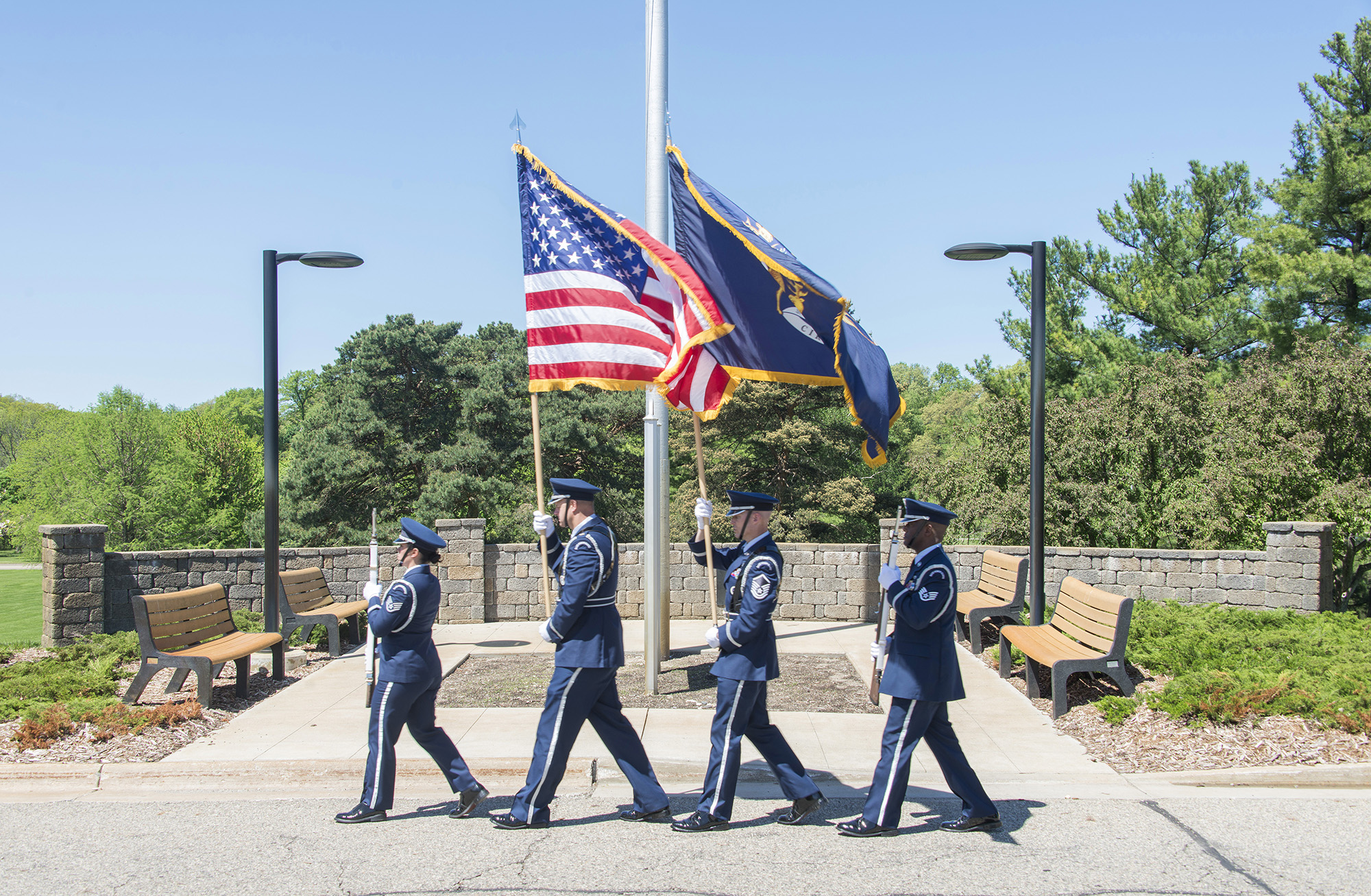 A military color guard carries the U.S. and Michigan flags during a Memorial Day event on campus.