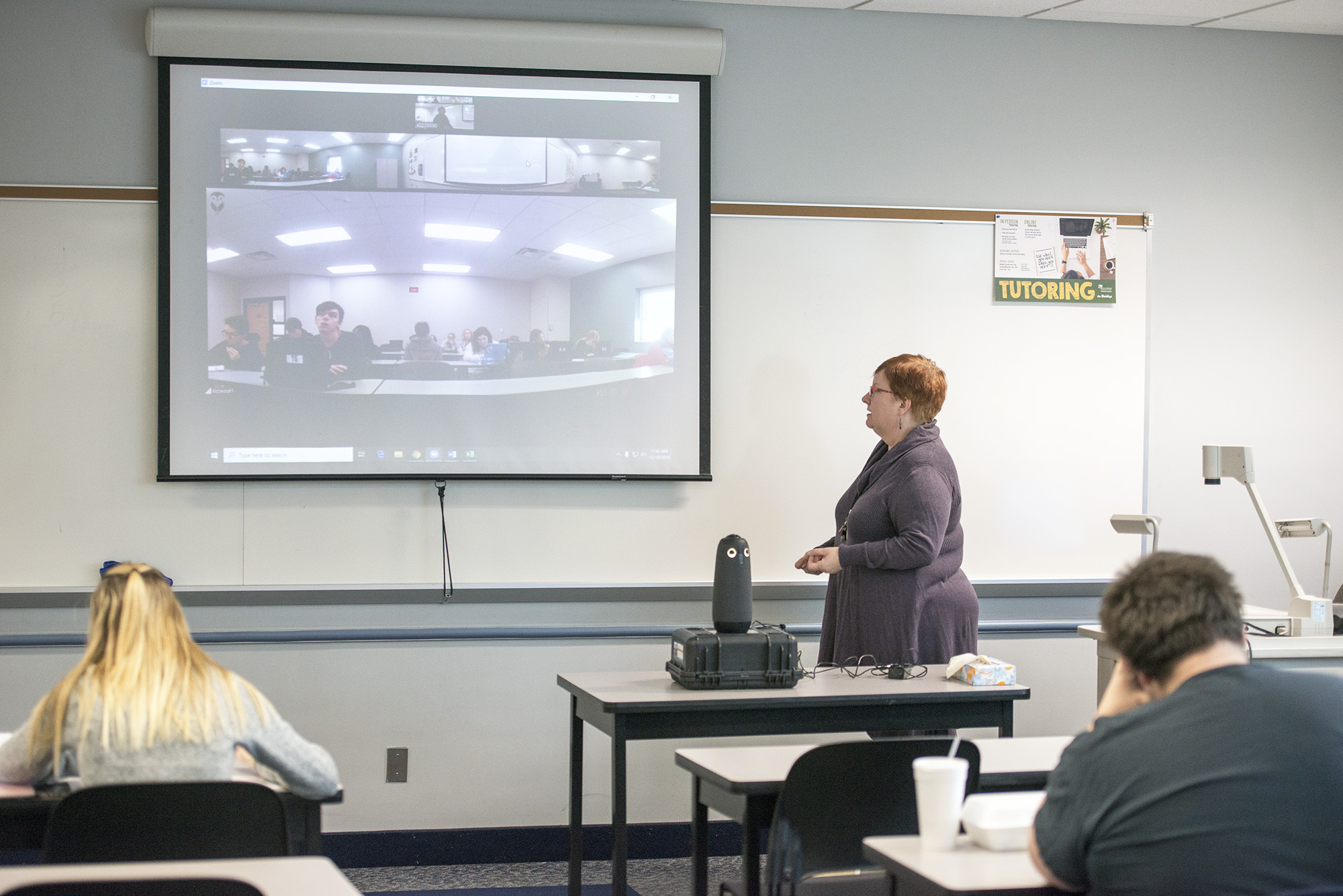 History professor Michelle Wright teaches a class on campus in Battle Creek while teaching students in Albion remotely via a video feed.