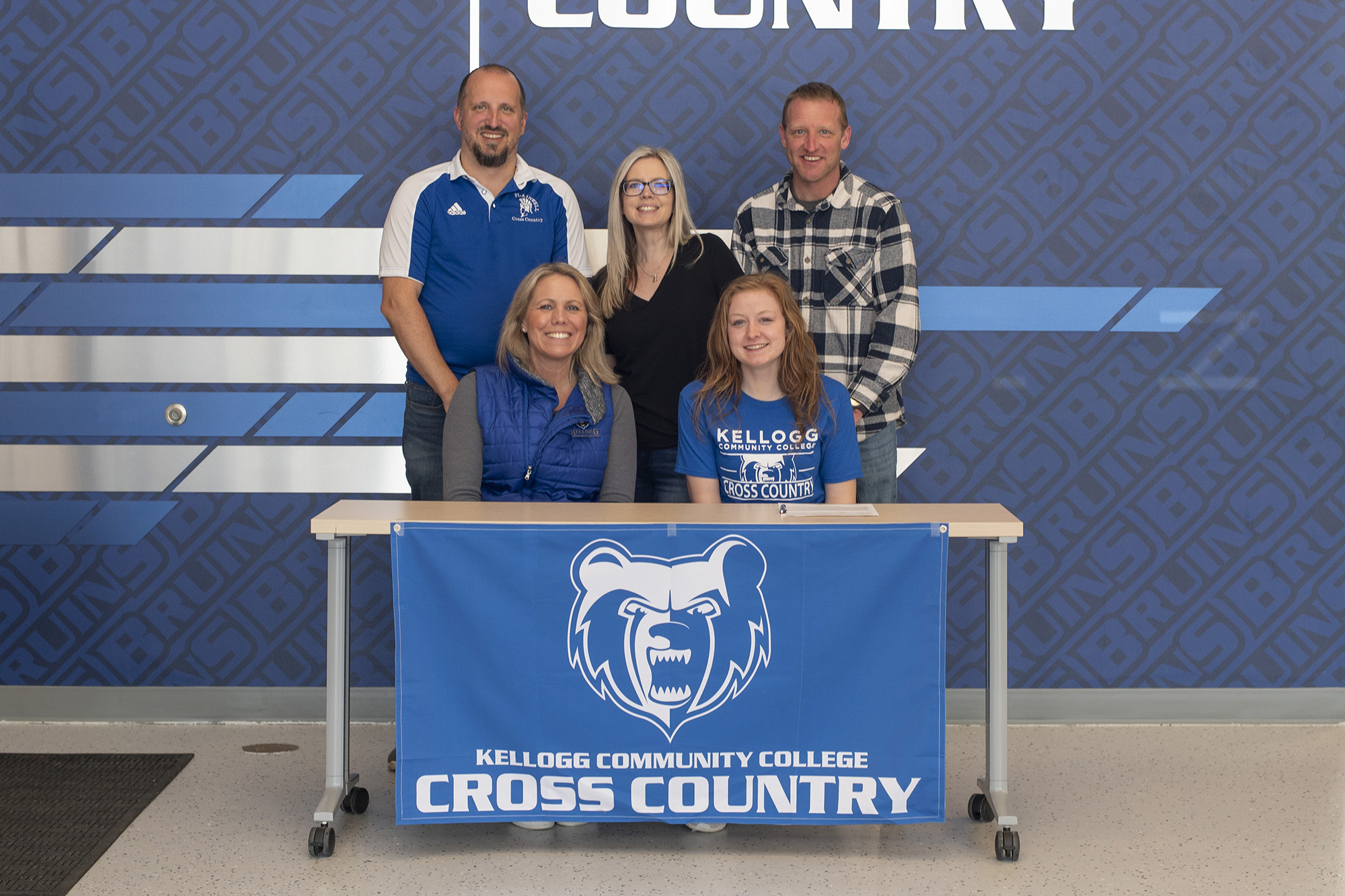In the front row, from left to right, are Head KCC Cross-Country Coach Erin Lane and Kennedy VanderLugt. In the back row, from left to right, are Plainwell High School Girls Cross-Country Coach Brett Beier, Jeanna VanderLugt (mother) and Ben VanderLugt (father).