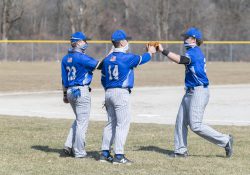 KCC baseball players greet each other off the field between innings.