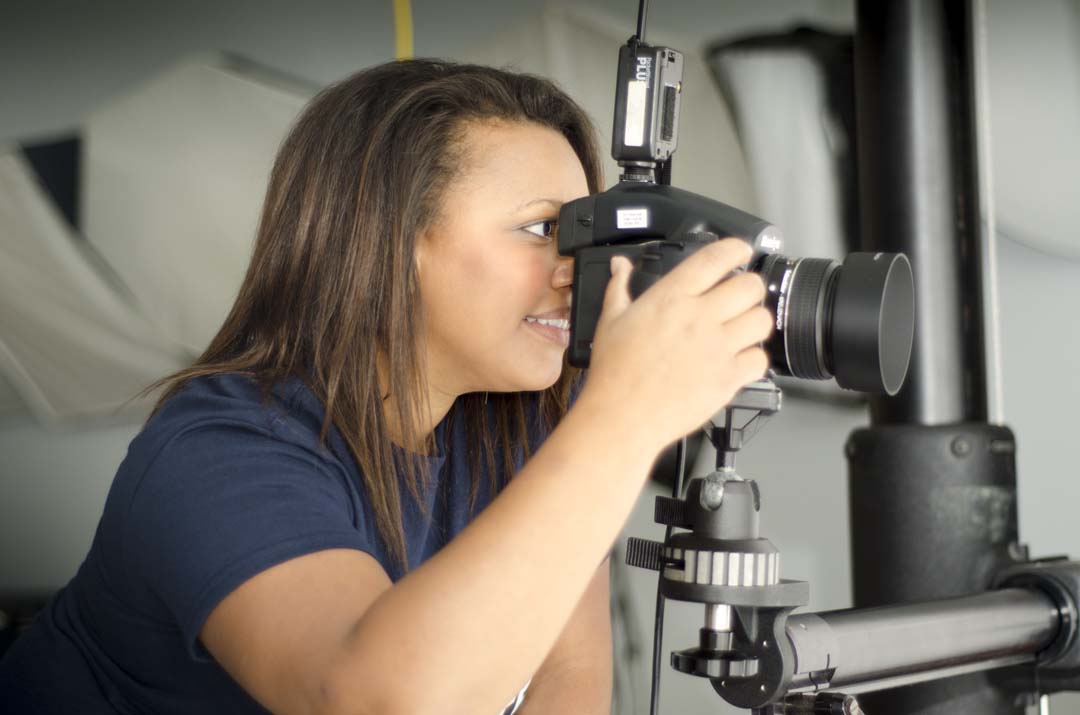 A female student uses a camera on a tripod.
