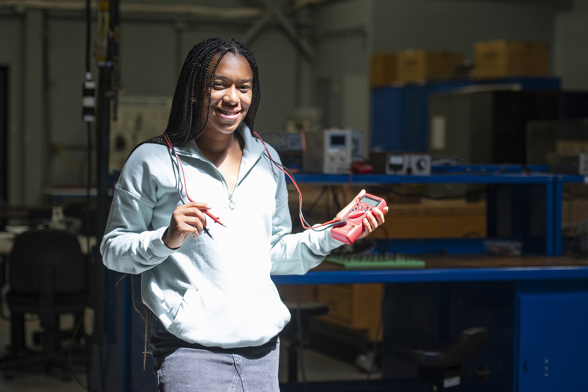 Student Zaire Gilbert holds an electrical meter tool in the College's Electricity and Electronics Lab.