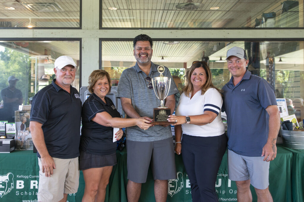 Interim KCC President Dr. Paul Watson holds a trophy with the four winners of the Bruin Open Mixed Division.