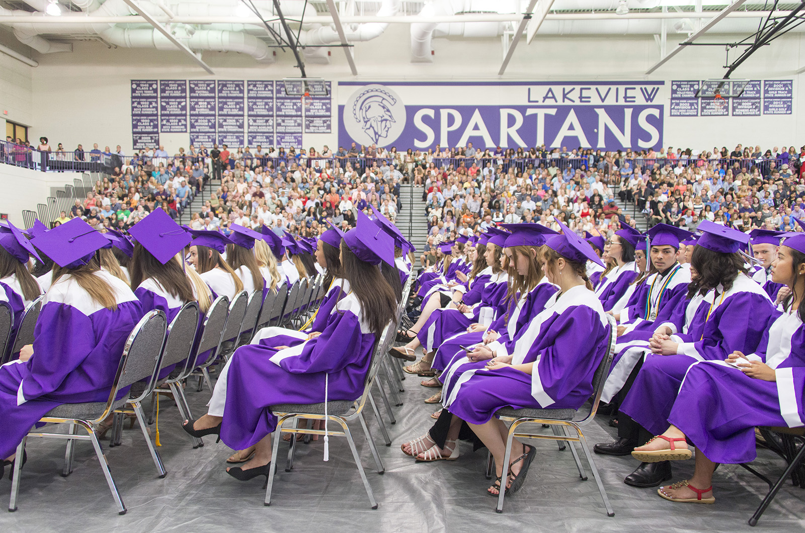 Lakeview graduates sit in purple caps and gowns during commencement.