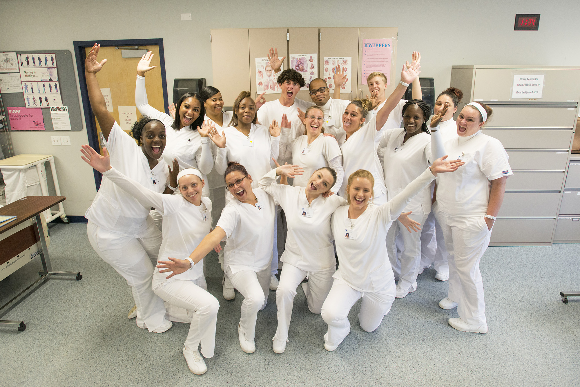 A group photo of CNA graduates celebrating their graduation in a CNA Lab on campus.