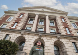 Eric McClure poses outside with City Hall behind him.