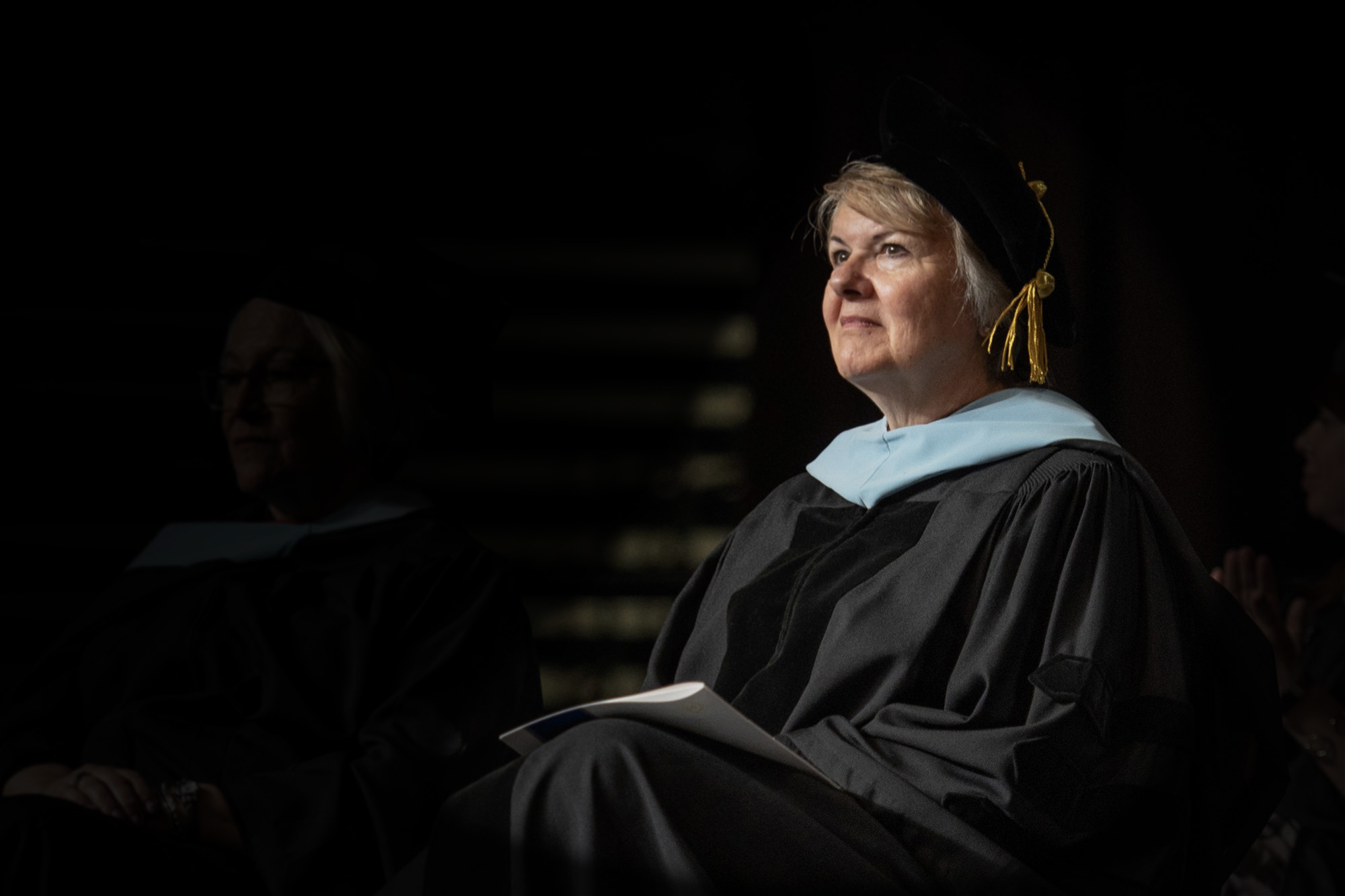 Dr. Kay Keck seated on stage during commencement.