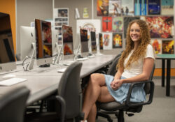 Jaelyn Hampton sits in the Graphic Design Lab.