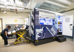 EMS students load a stretcher into an ambulance simulator in the EMS Lab.