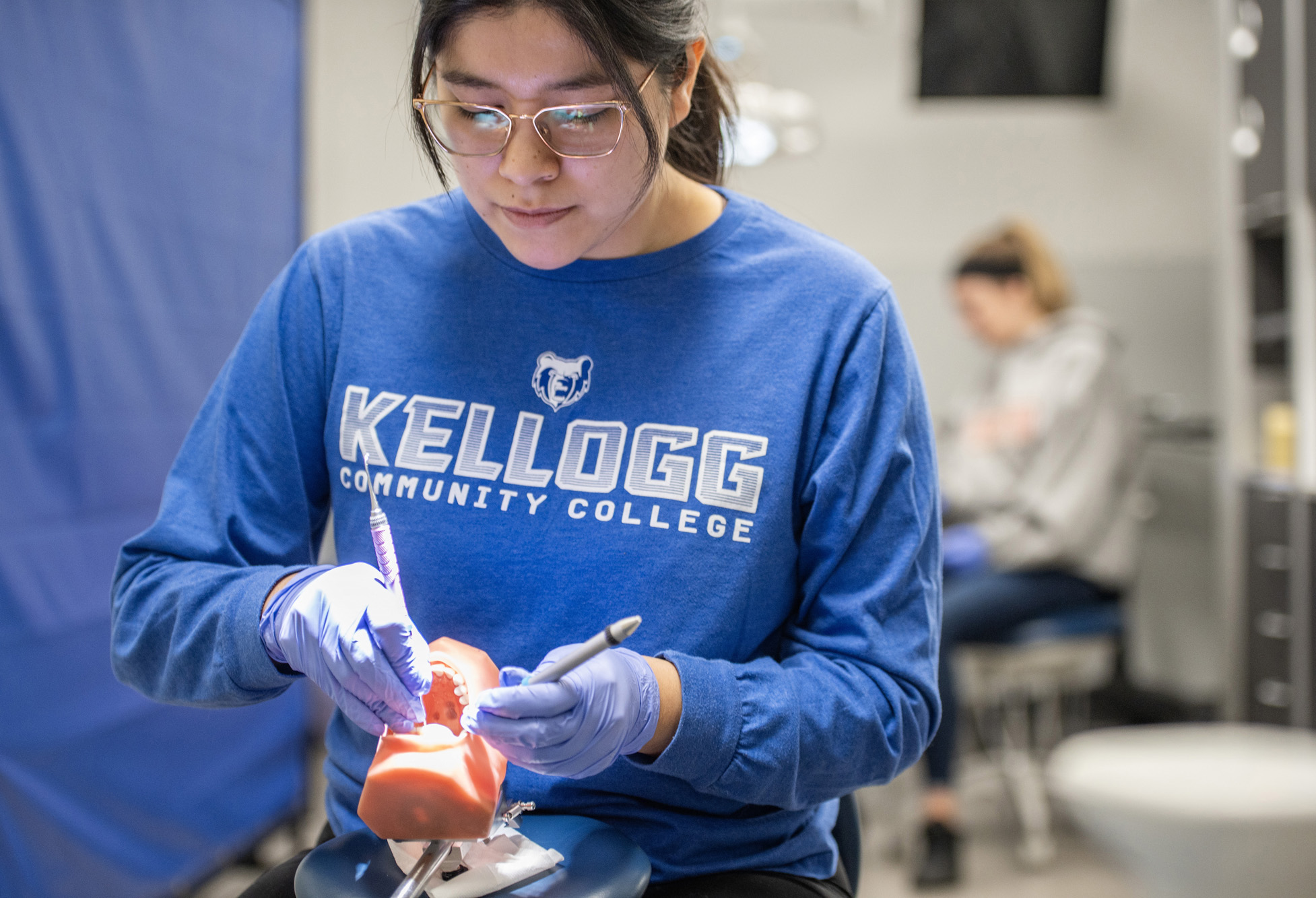 A Dental Hygiene student works cleaning model teeth in the on-campus clinic.