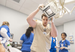 A Radiography student prepares to take an X-ray during a sim lab exercise.
