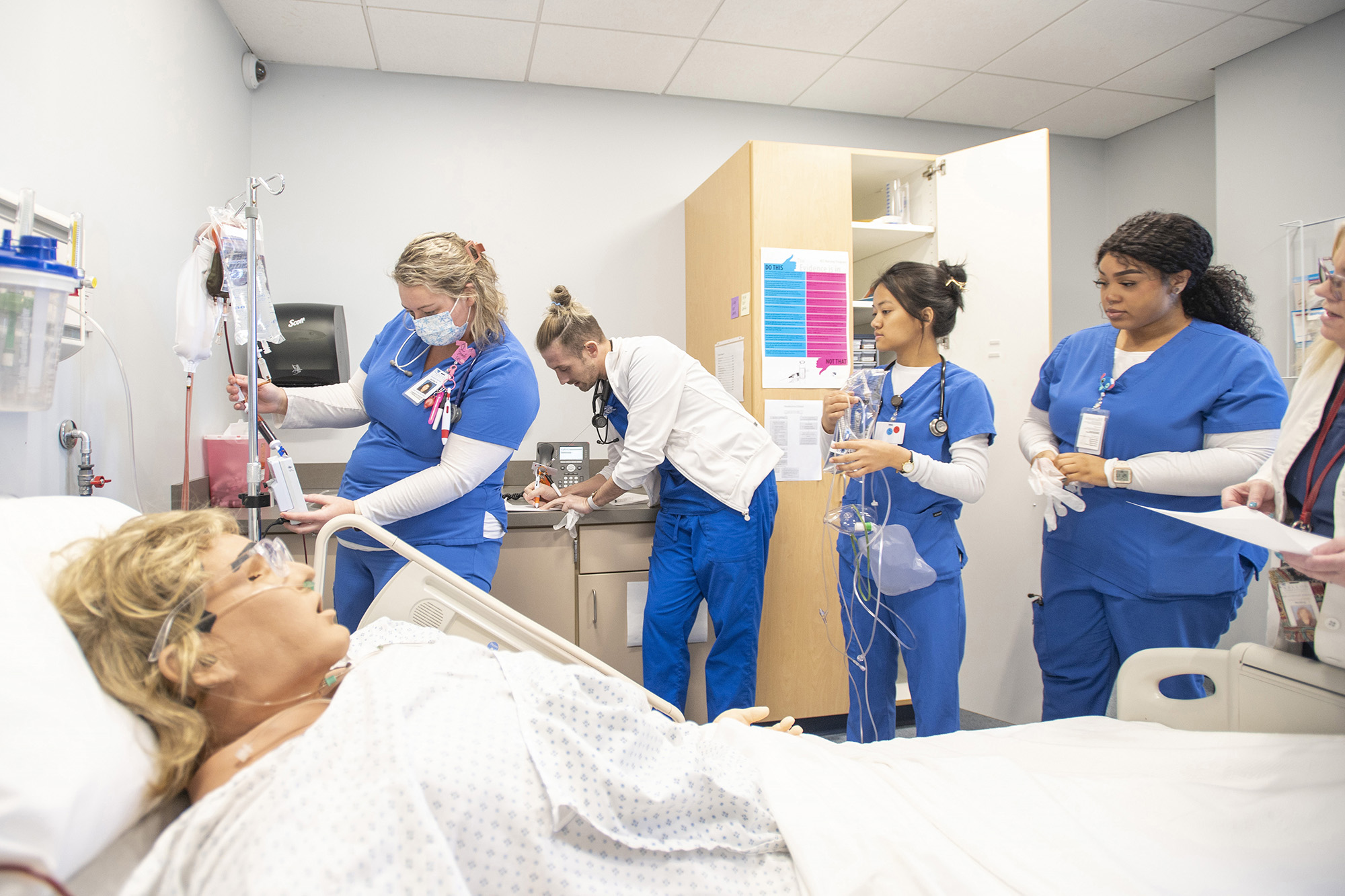 Nursing students work on a patient during simulation exercises in a lab on campus.