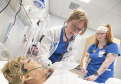 Nursing students work on a manikin patient during simulation exercises in a sim lab on campus.