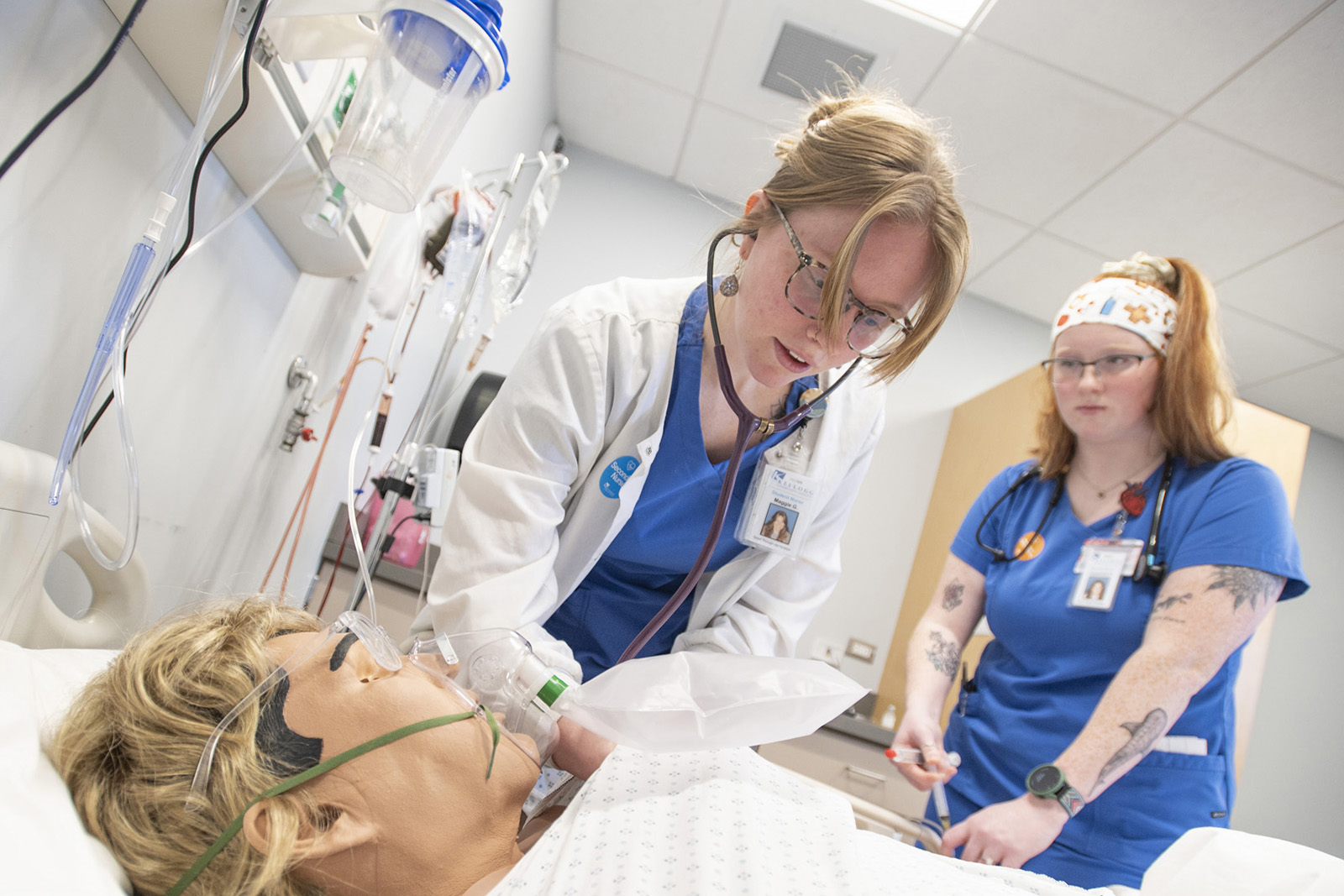 Nursing students work on a manikin patient during simulation exercises in a sim lab on campus.