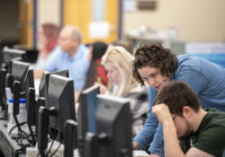 An instructor assists a student on a computer in the Center for Student Success.