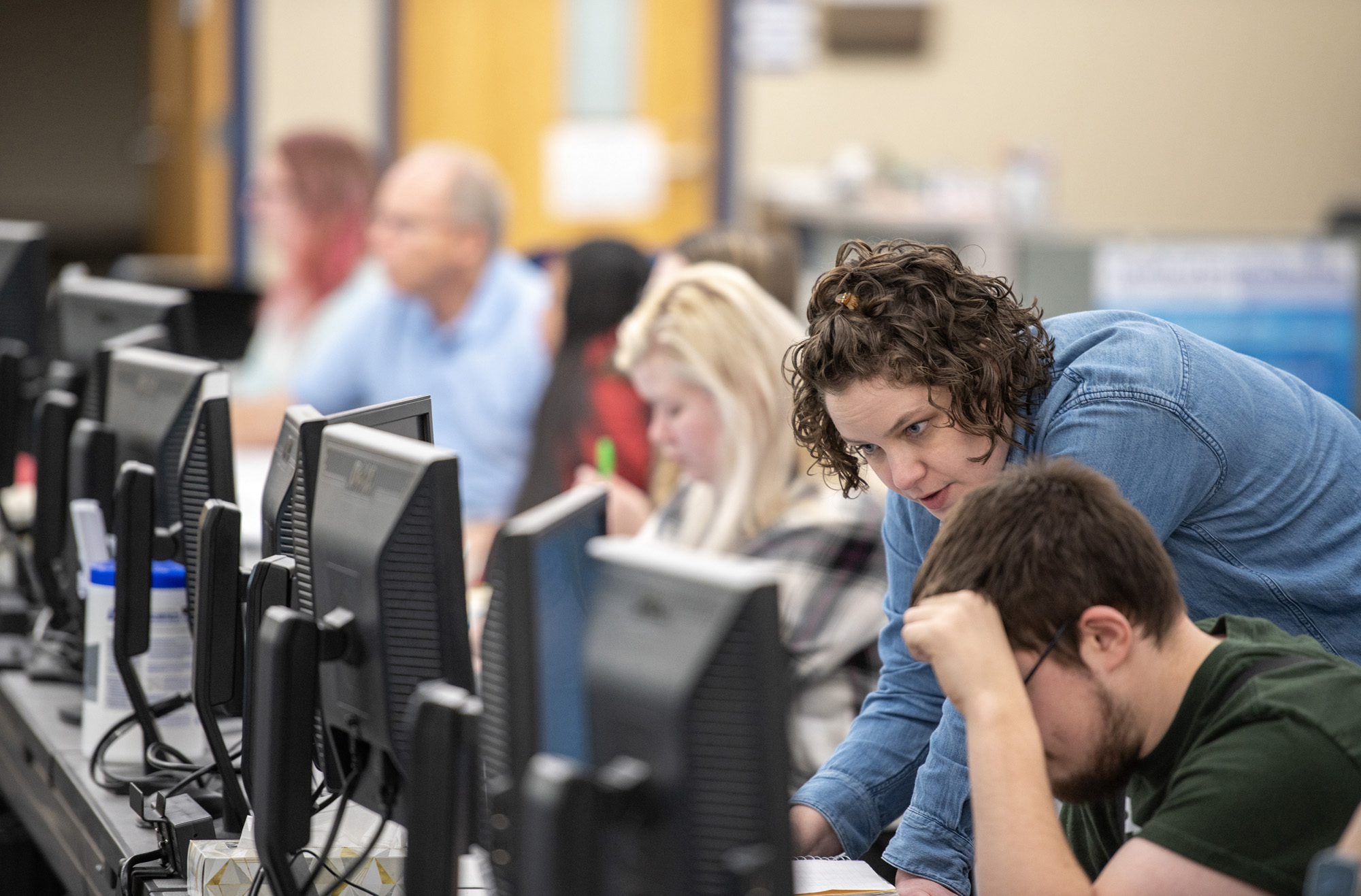 An instructor assists a student on a computer in the Center for Student Success.