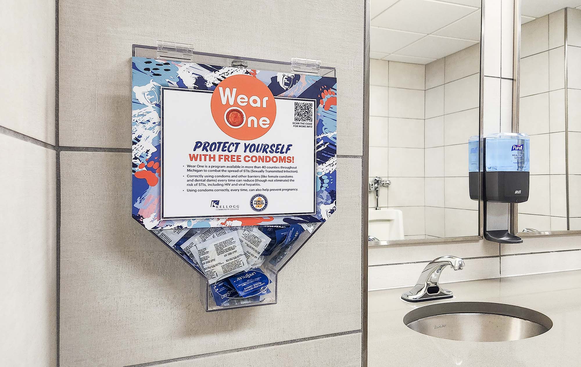 A Wear One condom dispenser installed on a bathroom wall on campus.