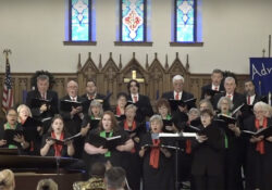 Choir members sing in a church during a concert.