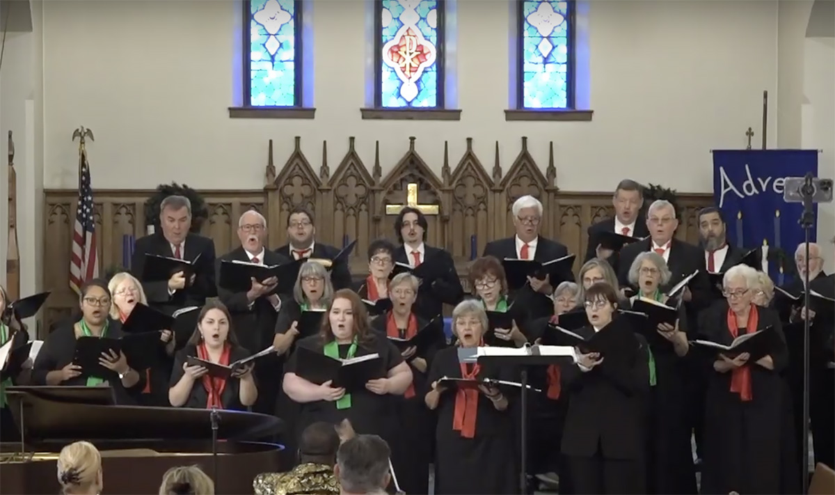 Choir members sing in a church during a concert.