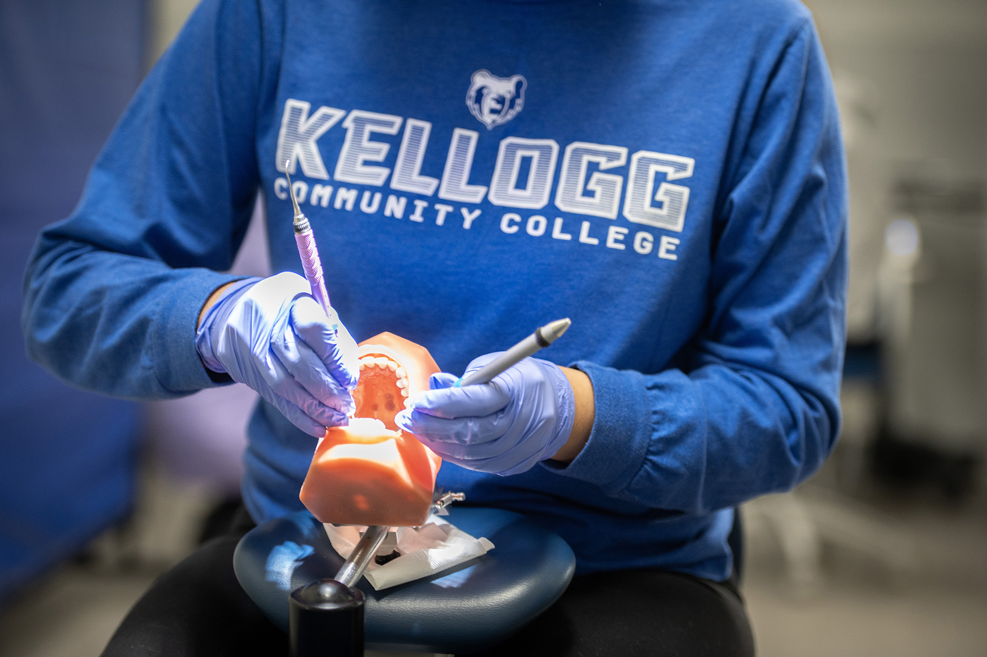 Close-up of a Dental Hygiene student practicing cleaning teeth on a model mouth.