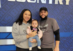 Evan Gray pictured with a woman holding a baby.