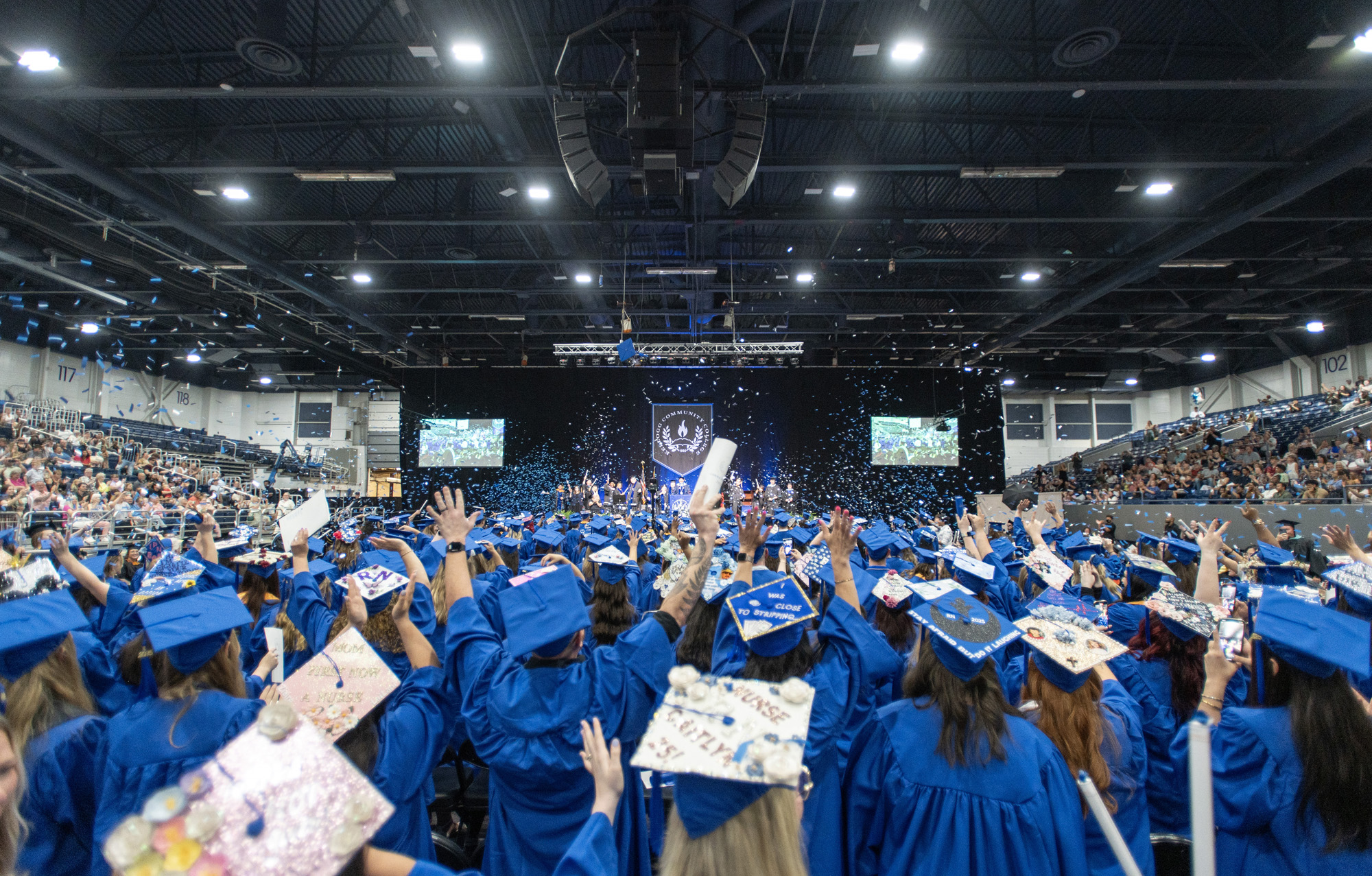 Graduates raise their hands in celebration at the end of Commencement.