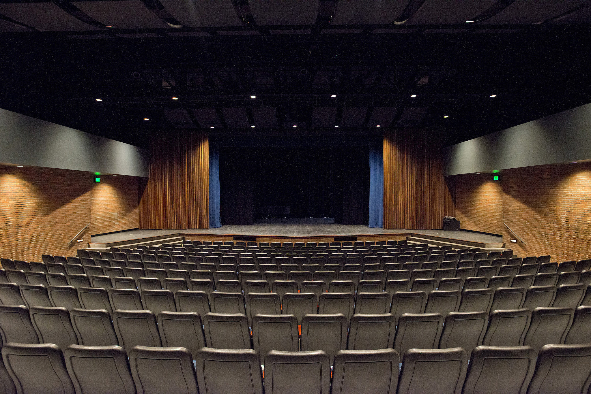 A view of an empty Binda Performing Arts Center theatre space looking toward the empty stage over empty audience seating.