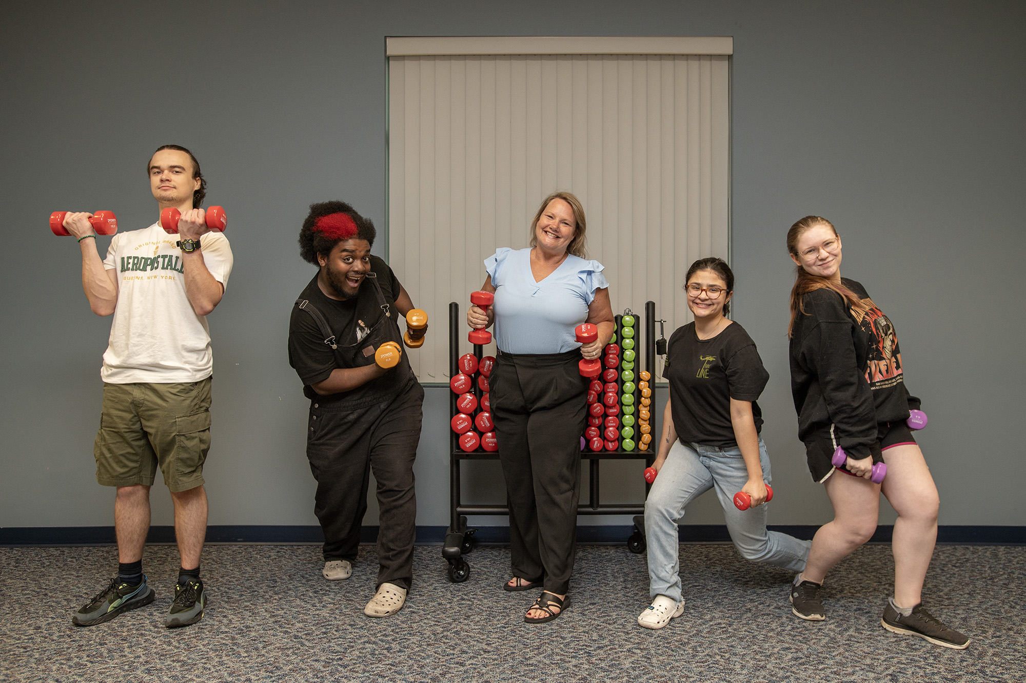 Five individuals pose for a photo with new strength training equipment.
