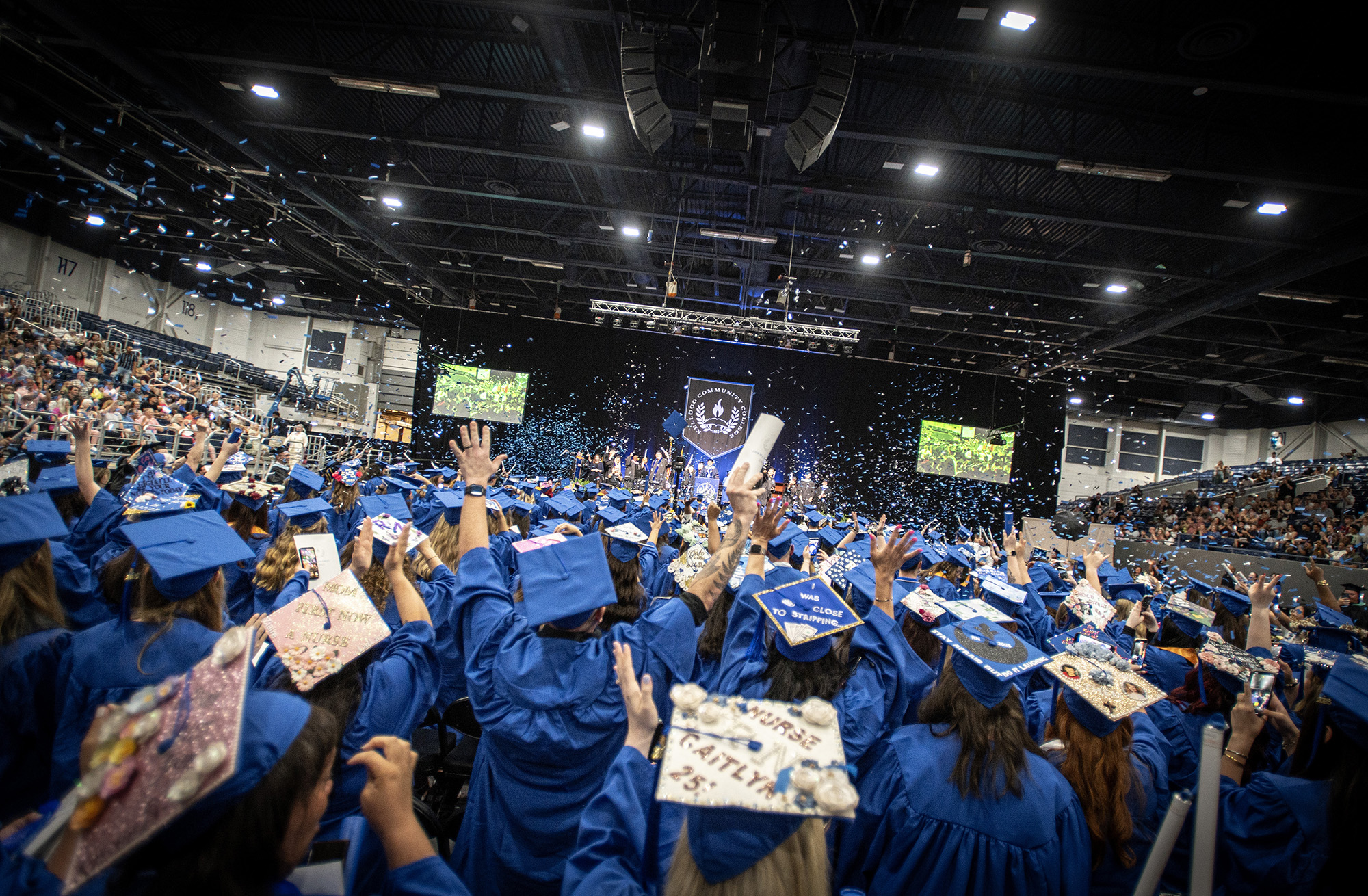 Graduates raise their hands in celebration at the end of Commencement.
