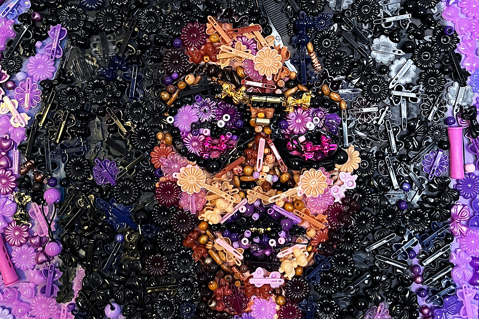 Detail from a mosaic portrait of a Black woman created out of everyday hair accessories by artist Keila Strong.