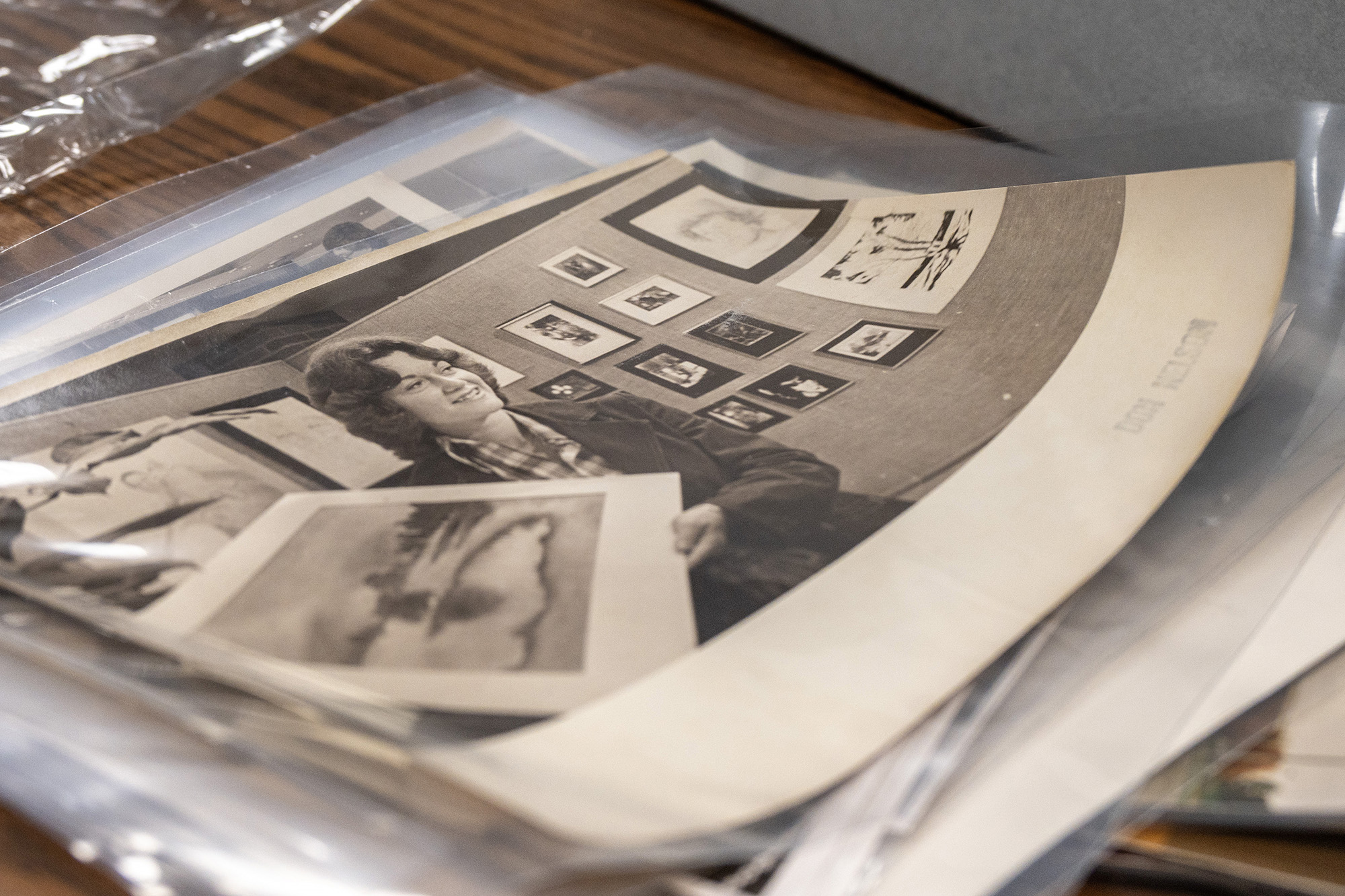 A stack of archival black and white photos from the KCC archives.