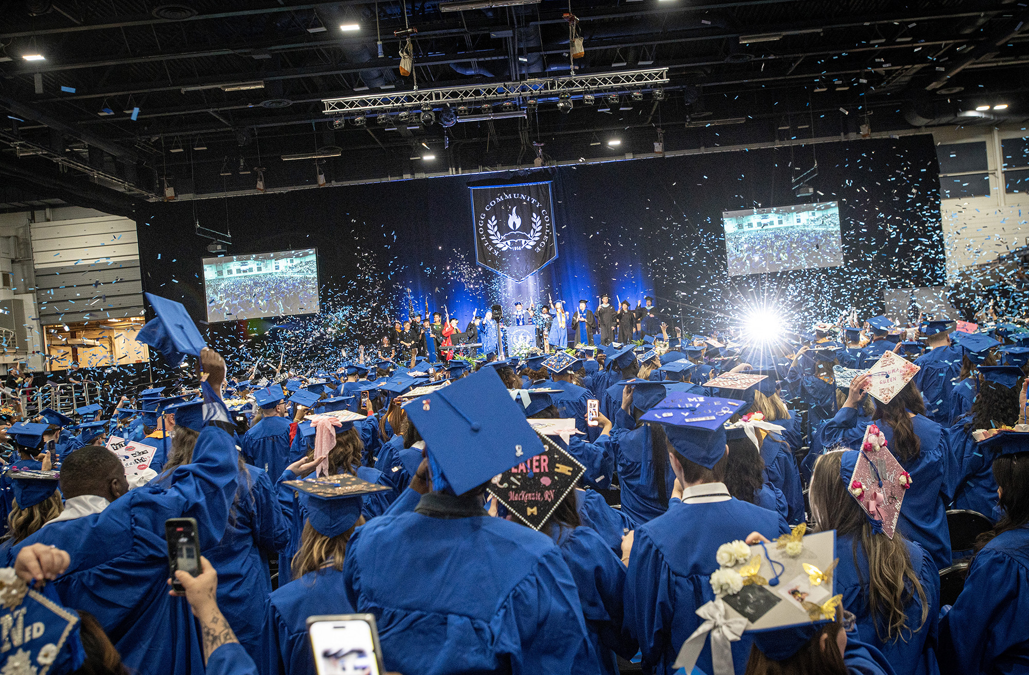 Graduates raise their hands in celebration at the close of KCC's 2026 Commencement ceremony.