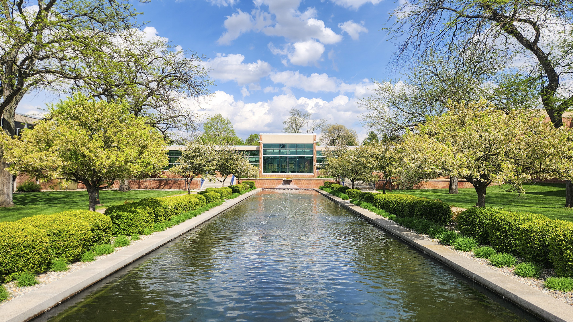 An exterior view of campus looking over the reflecting pools on a sunny day.