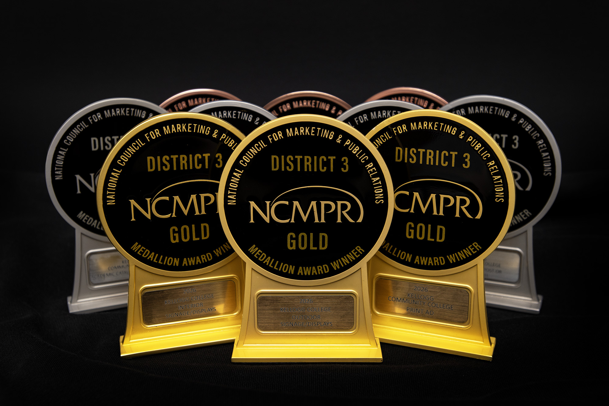 A photo of KCC's 10 Medallion Awards set against a black backdrop.