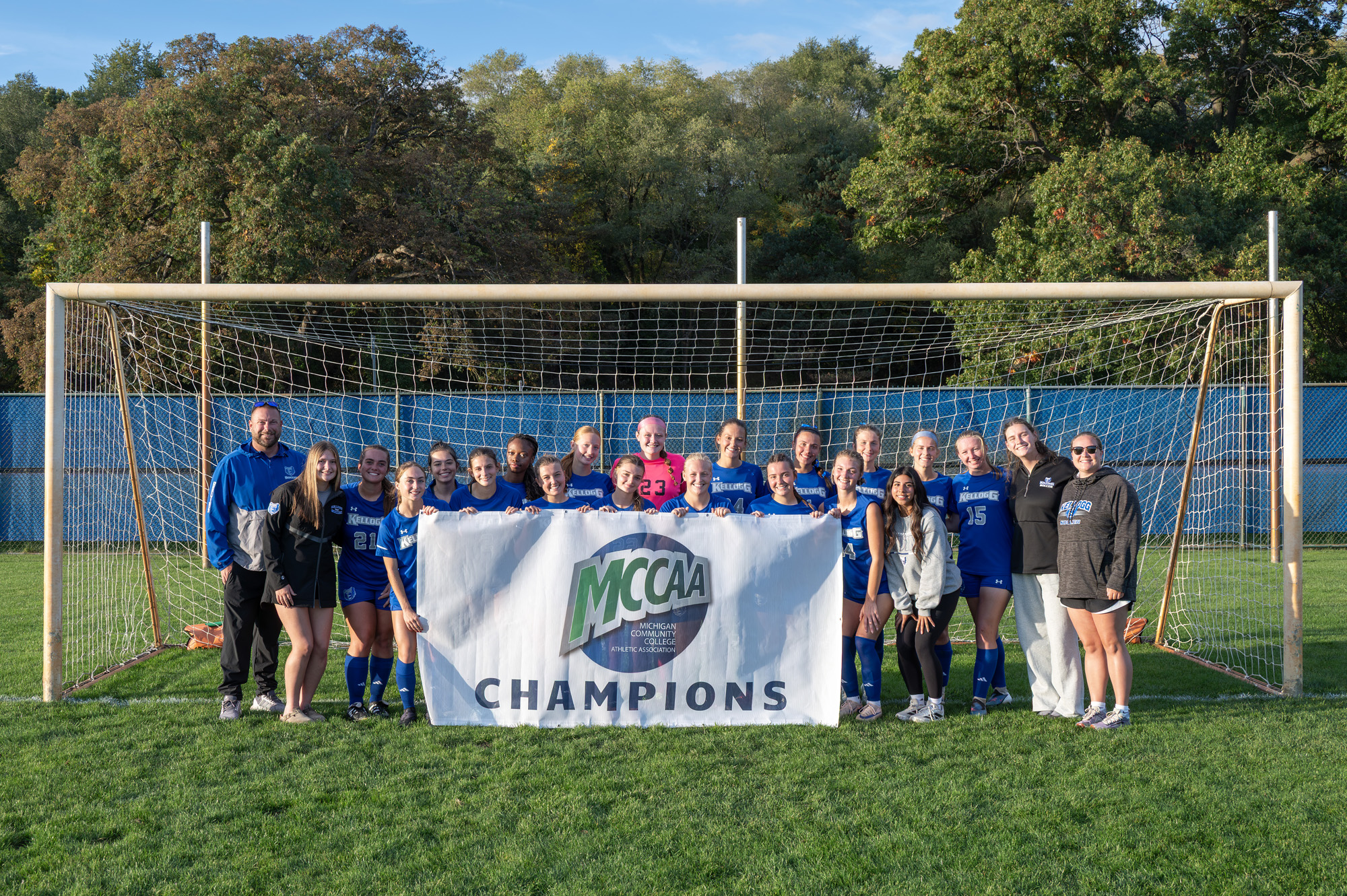 The women’s soccer team holding up a banner that reads, “MCCAA Champions.”